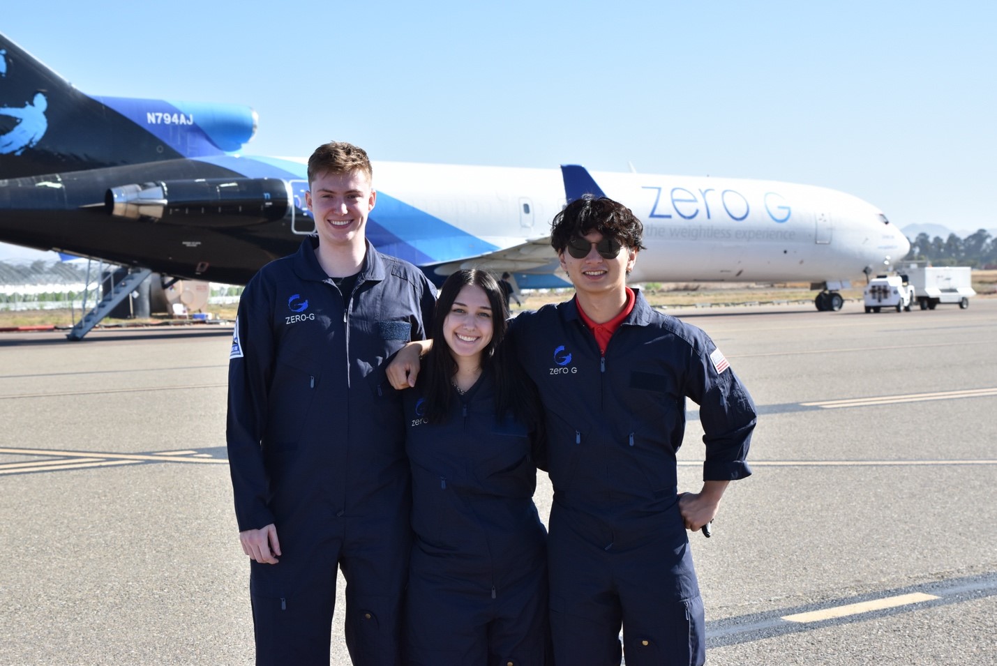 Ohio State students (left to right) Grant Smith, Sarah Huetter, and Eugene Choi pose for a photo before their flight in front of the Zero G Boeing 727 on the Santa Maria Airport tarmac